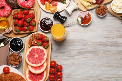 Photo of Different tasty food served for brunch on wooden table, flat lay. Space for text