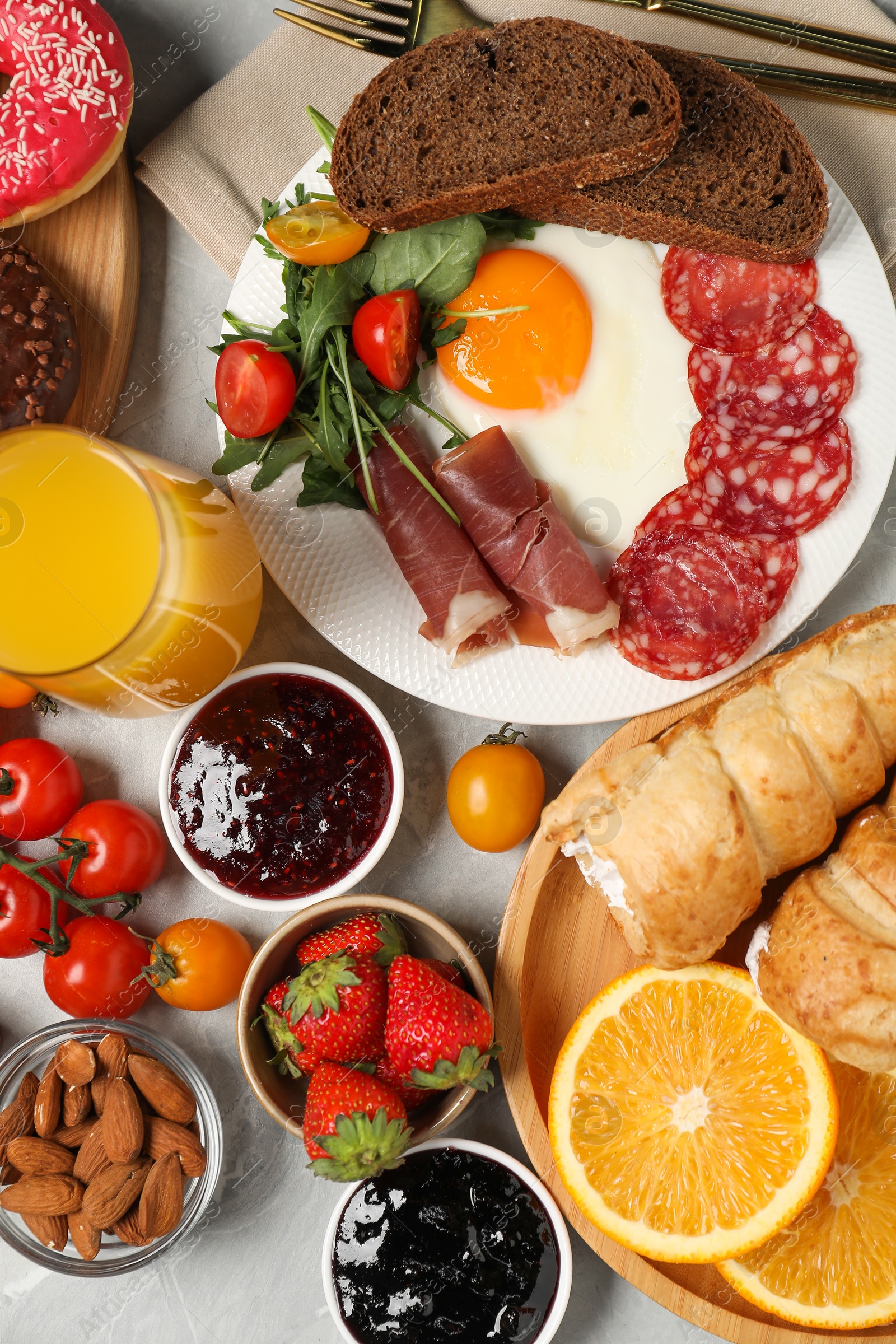 Photo of Different tasty food served for brunch on grey marble table, flat lay