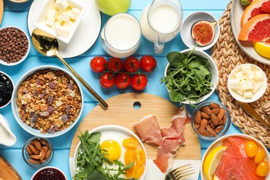 Photo of Different tasty food served for brunch on light blue wooden table, flat lay