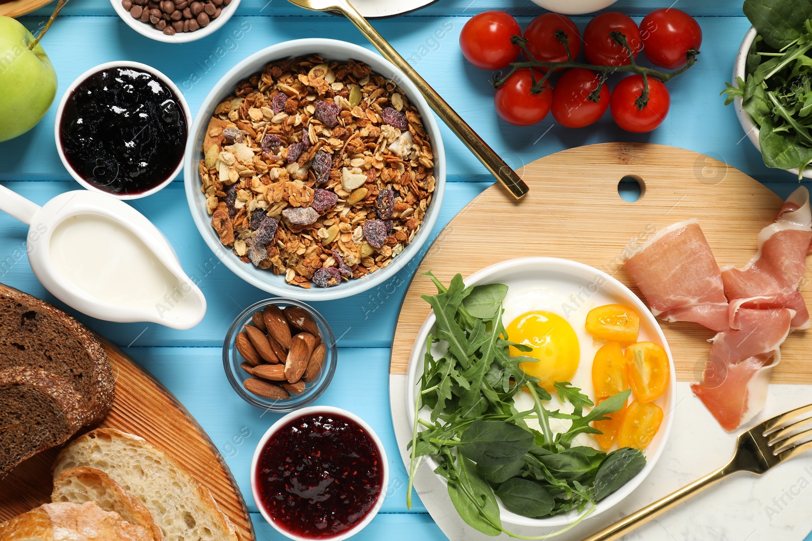 Photo of Different tasty food served for brunch on light blue wooden table, flat lay