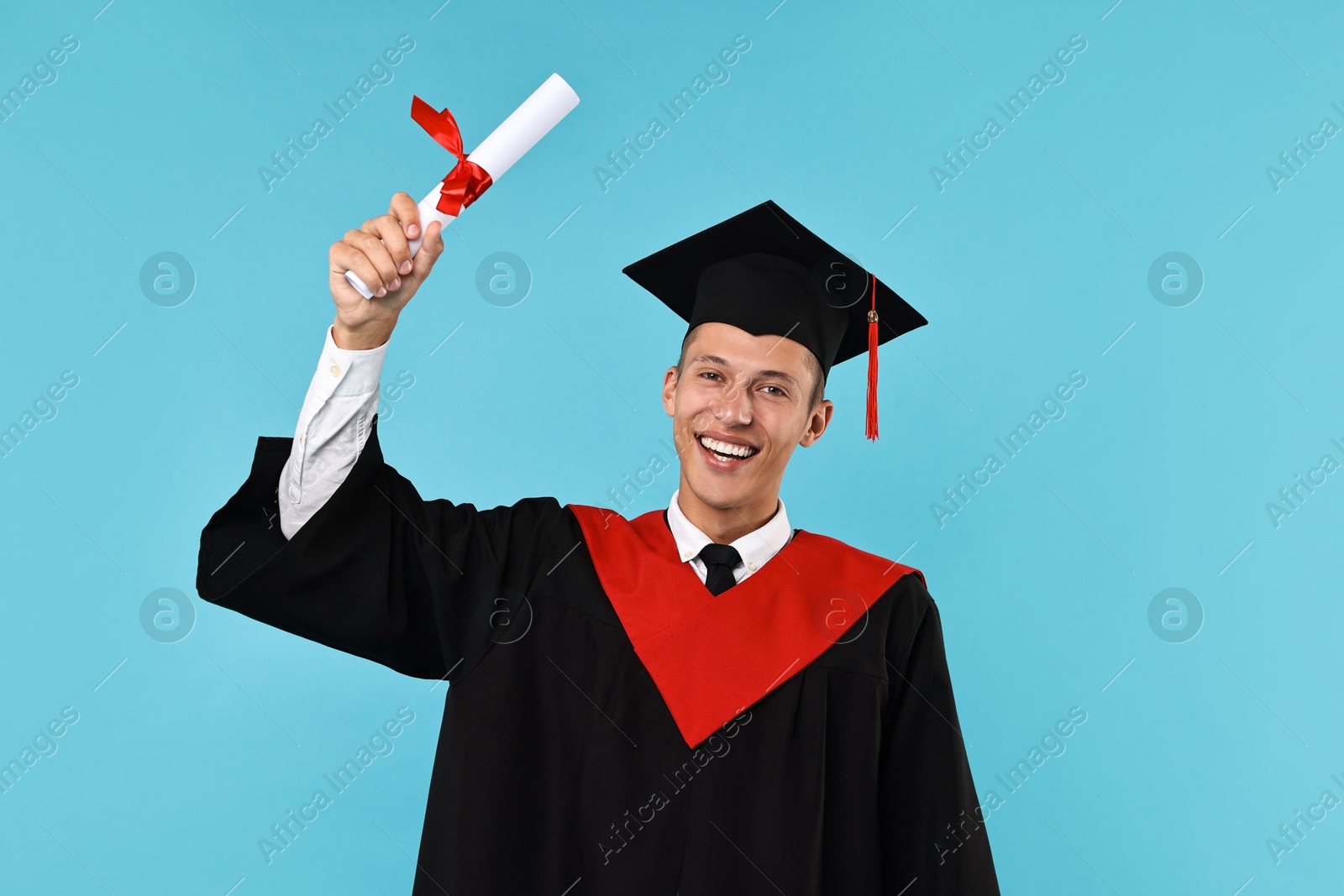 Photo of Happy student with diploma after graduation on light blue background