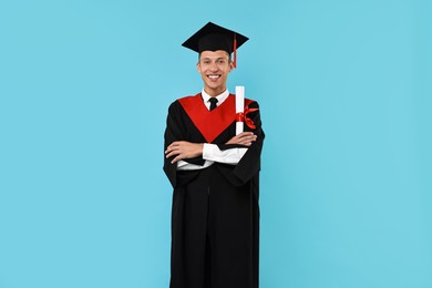 Photo of Happy student with diploma after graduation on light blue background