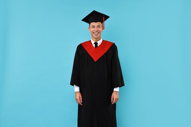 Photo of Happy student after graduation on light blue background