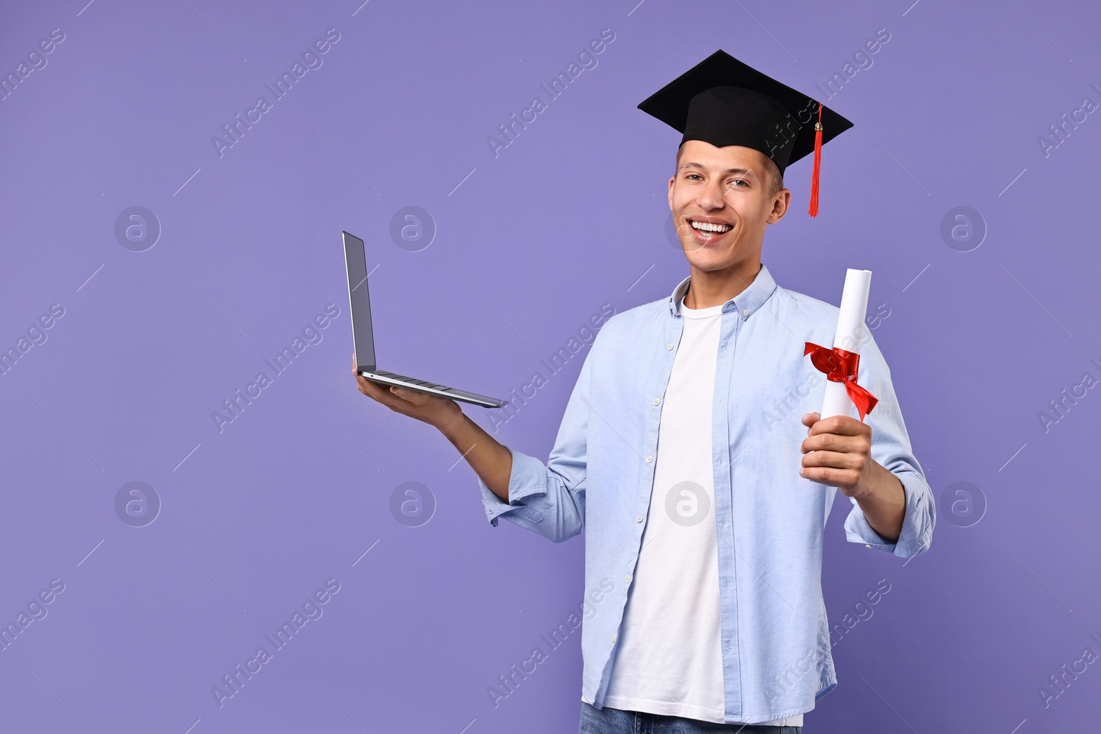 Photo of Happy student with laptop and diploma after graduation on violet background. Space for text