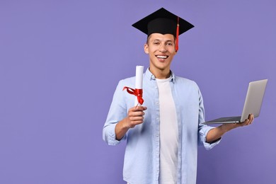 Happy student with laptop and diploma after graduation on violet background. Space for text