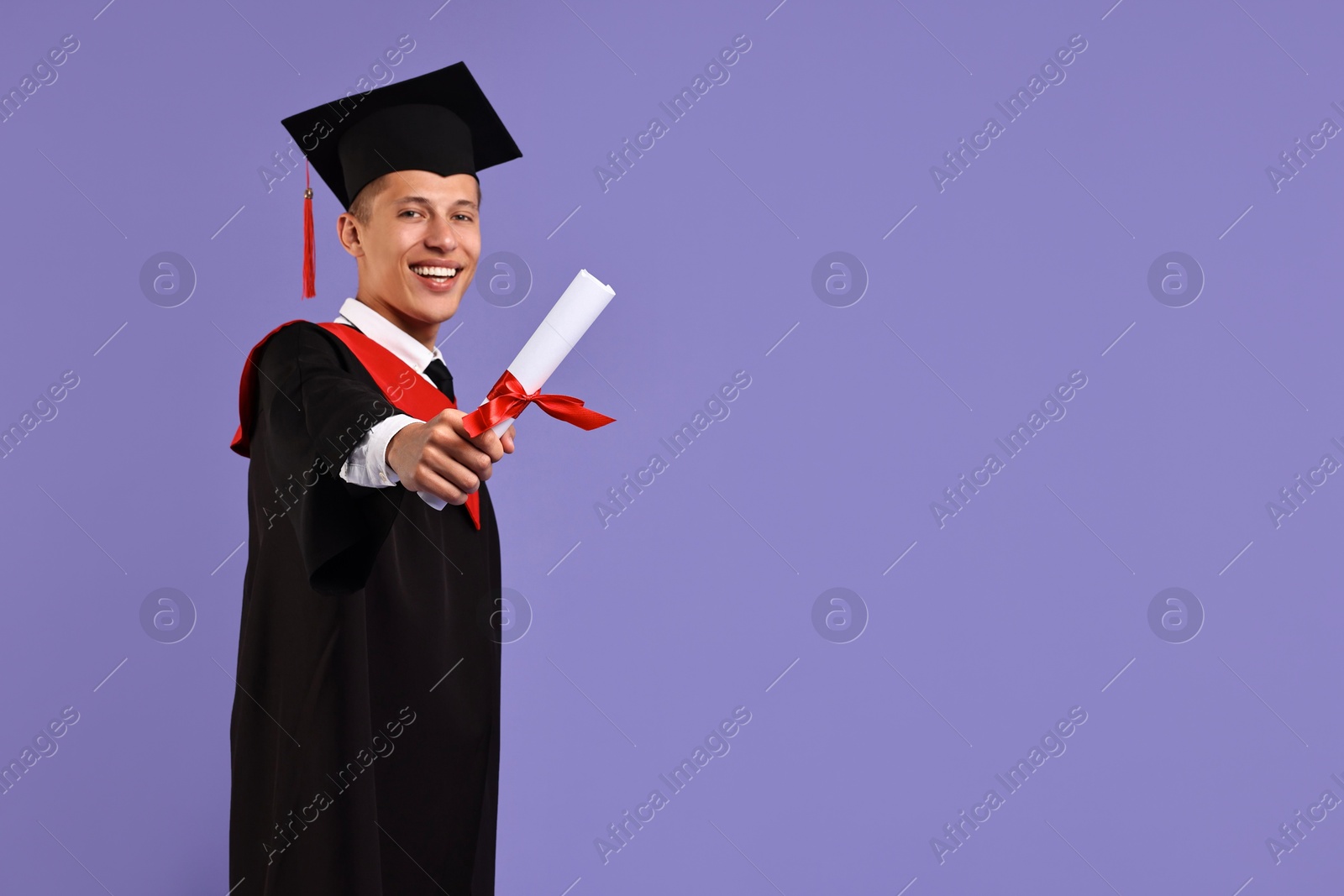 Photo of Happy student with diploma after graduation on violet background. Space for text