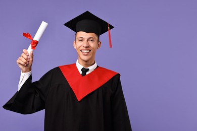 Photo of Happy student with diploma after graduation on violet background. Space for text