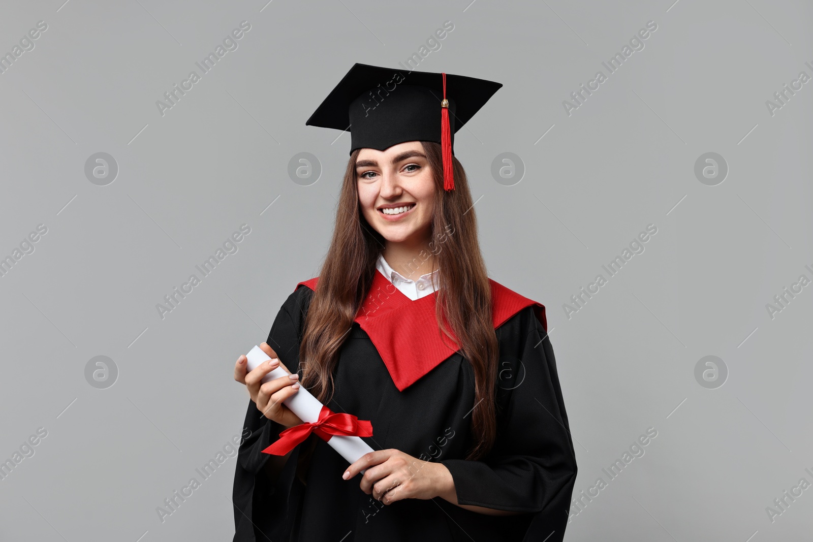 Photo of Happy student with diploma after graduation on grey background