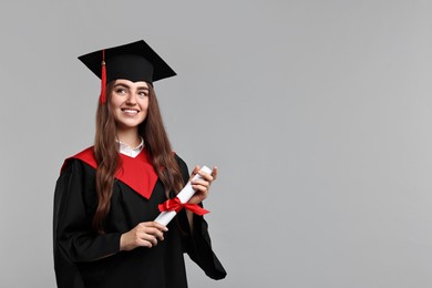 Photo of Happy student with diploma after graduation on grey background. Space for text