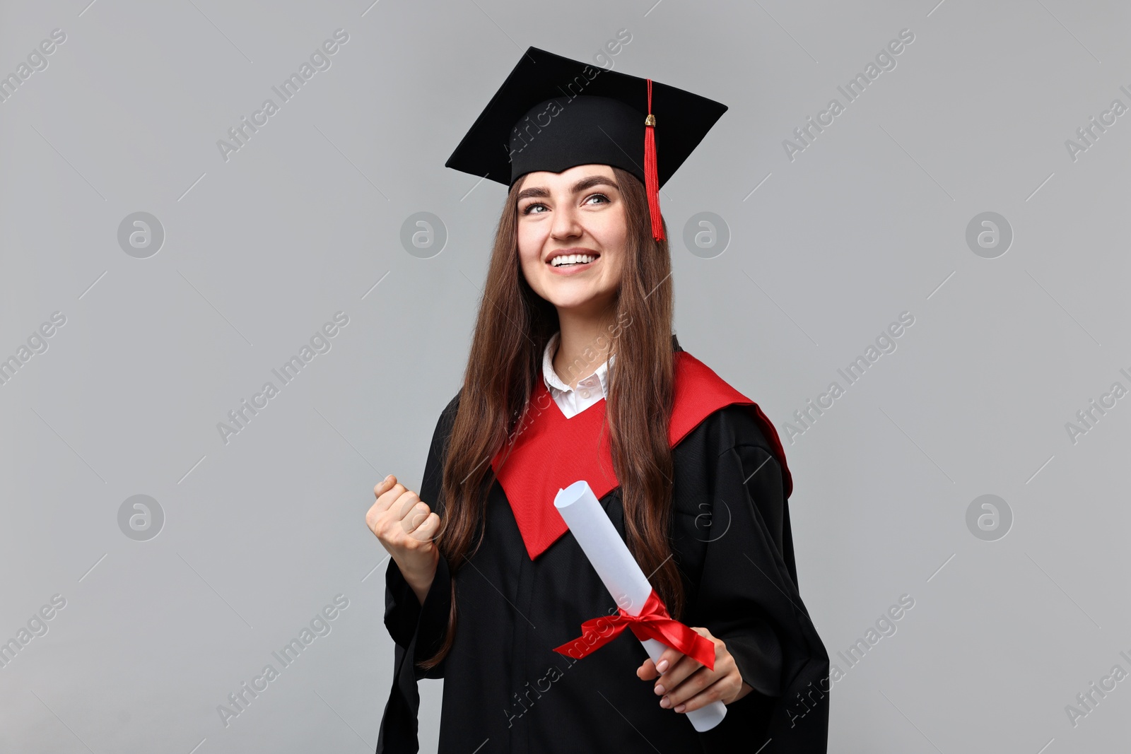 Photo of Happy student with diploma after graduation on grey background