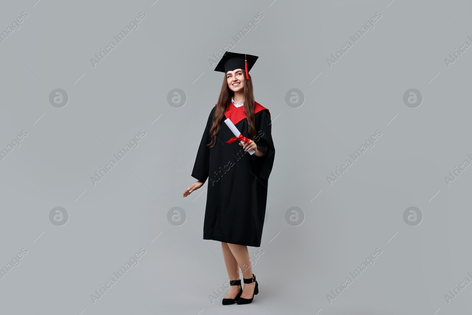 Photo of Happy student with diploma after graduation on grey background