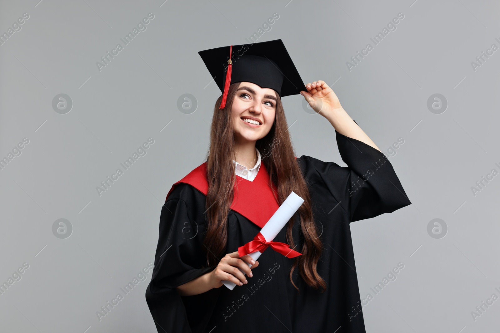 Photo of Happy student with diploma after graduation on grey background