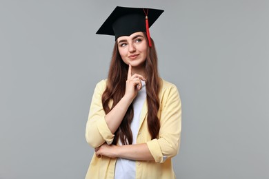 Photo of Thoughtful student after graduation on grey background