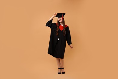 Photo of Happy student after graduation on beige background