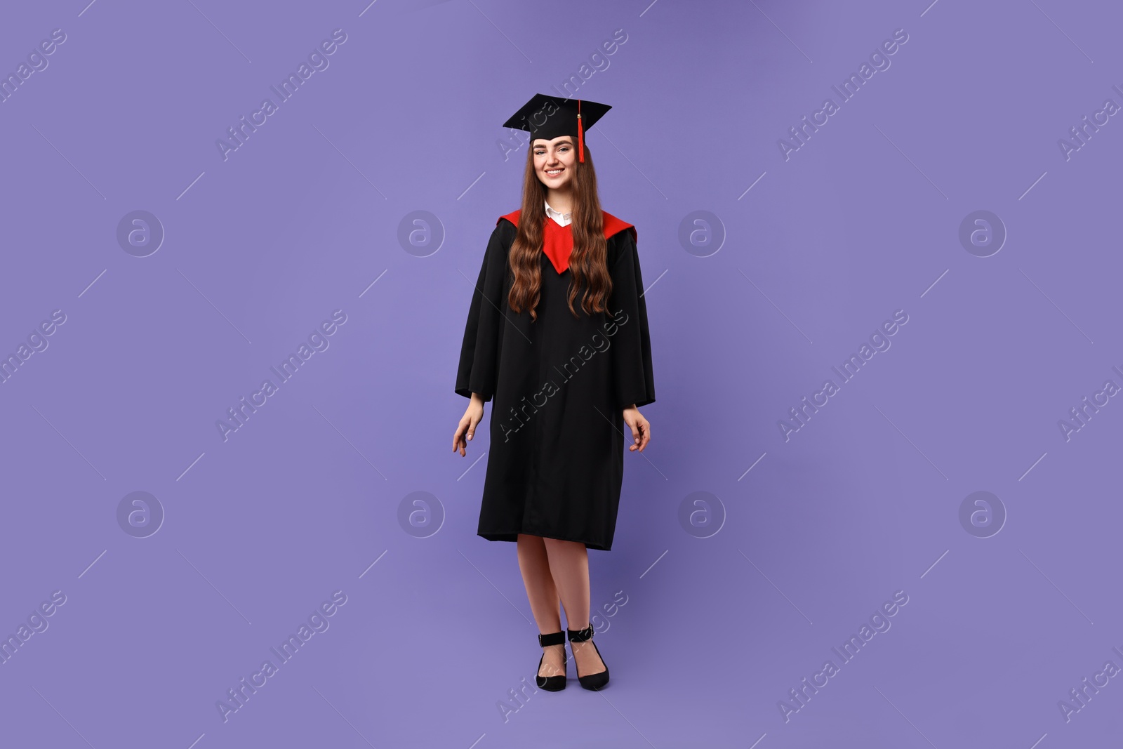 Photo of Happy student after graduation on violet background