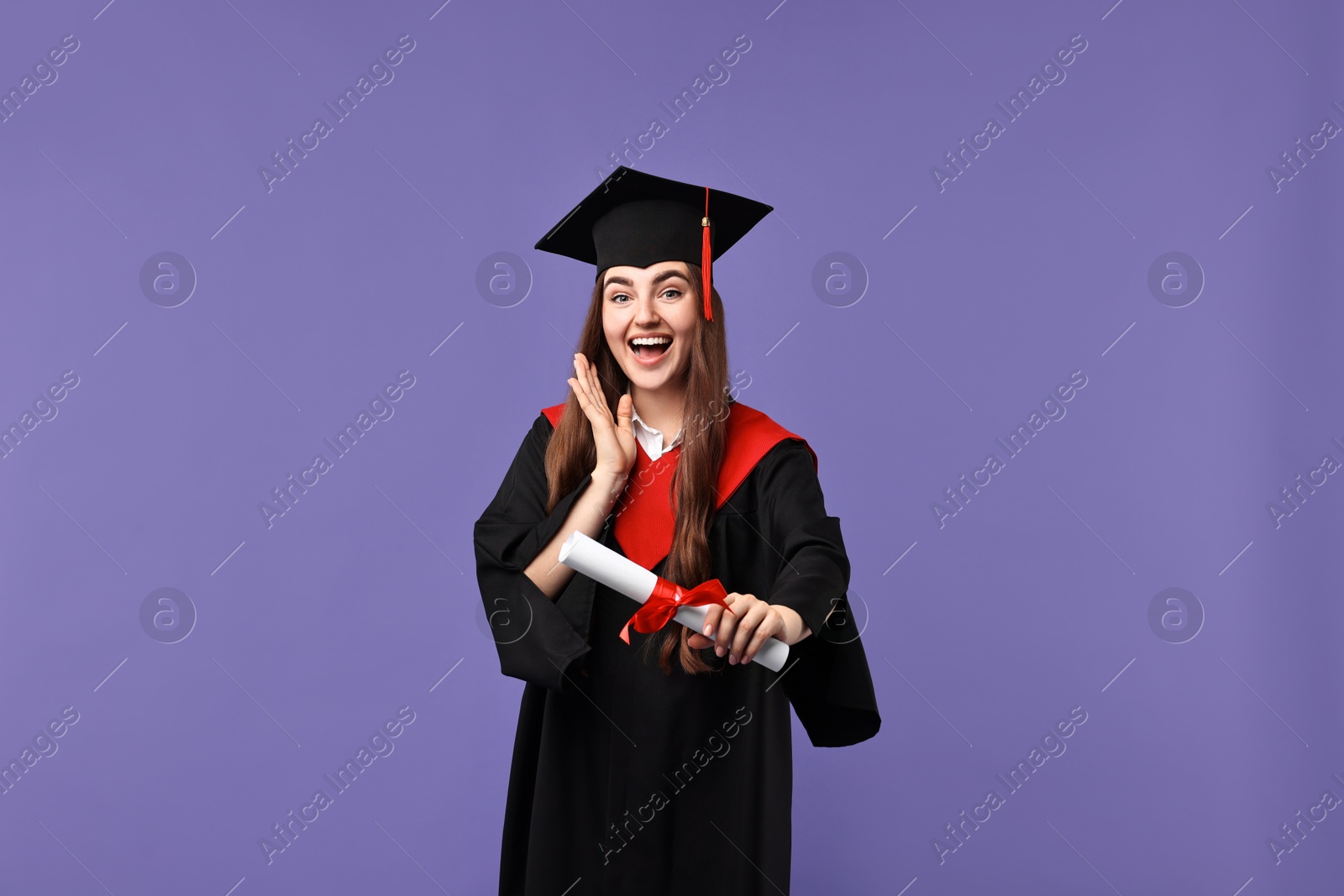 Photo of Happy student with diploma after graduation on violet background