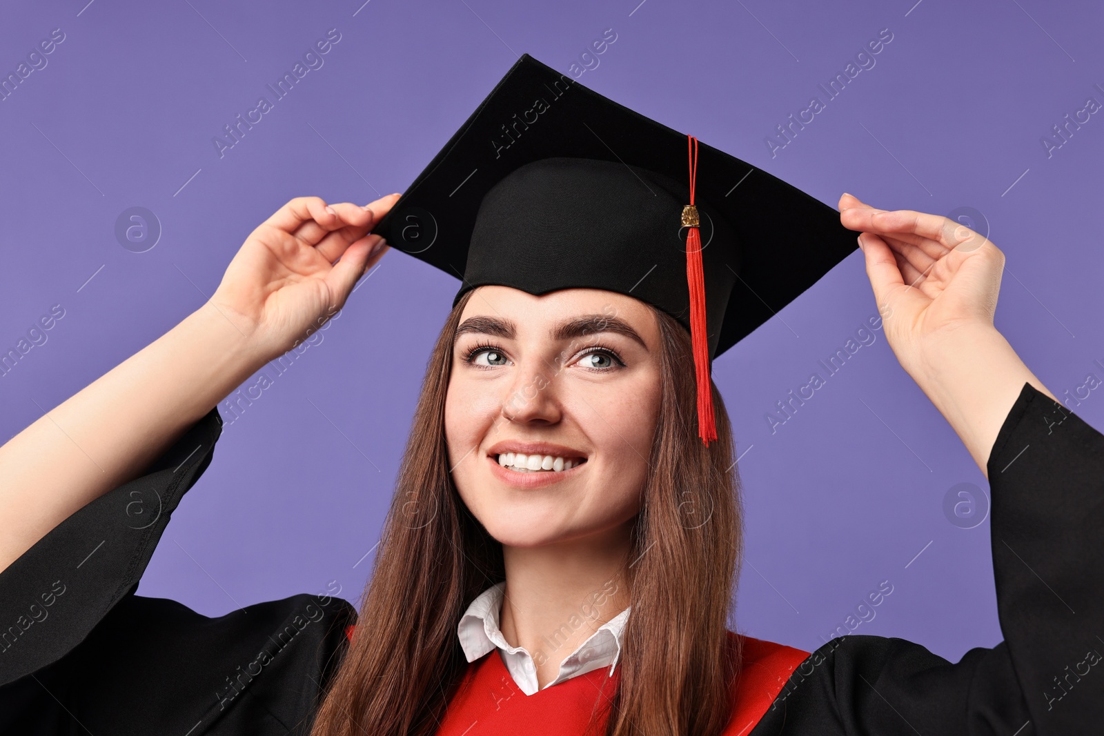 Photo of Happy student after graduation on violet background