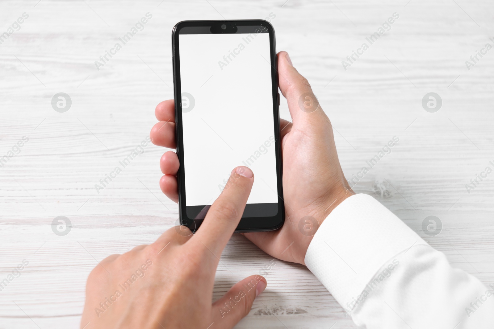 Photo of Man unlocking smartphone with fingerprint scanner at light wooden table, closeup