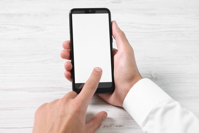 Photo of Man unlocking smartphone with fingerprint scanner at light wooden table, closeup