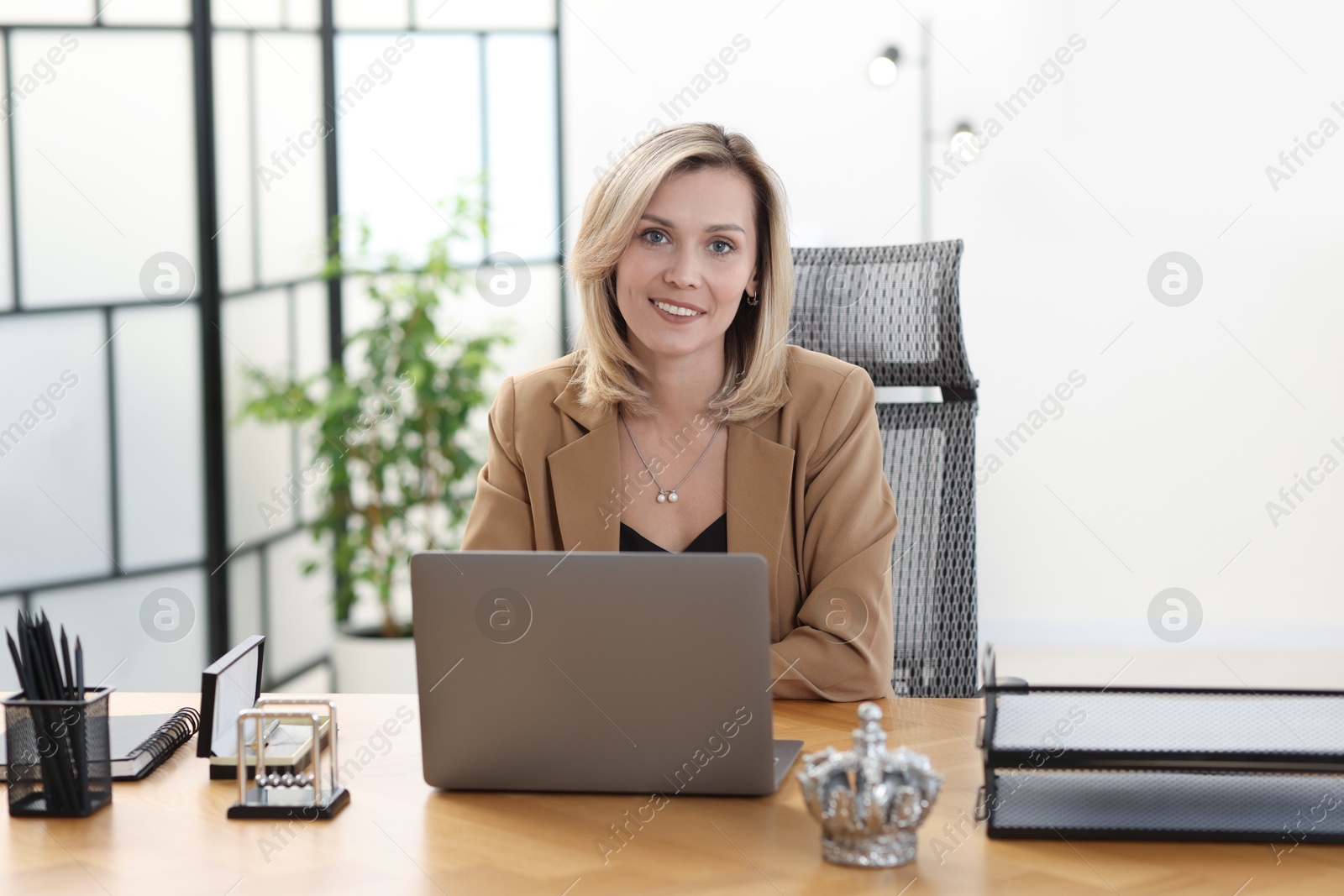 Photo of Businesswoman working on laptop at table in office