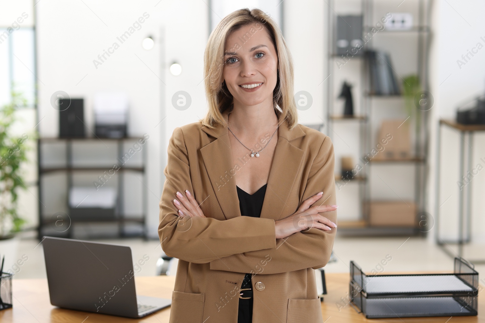 Photo of Portrait of happy businesswoman with crossed arms in office