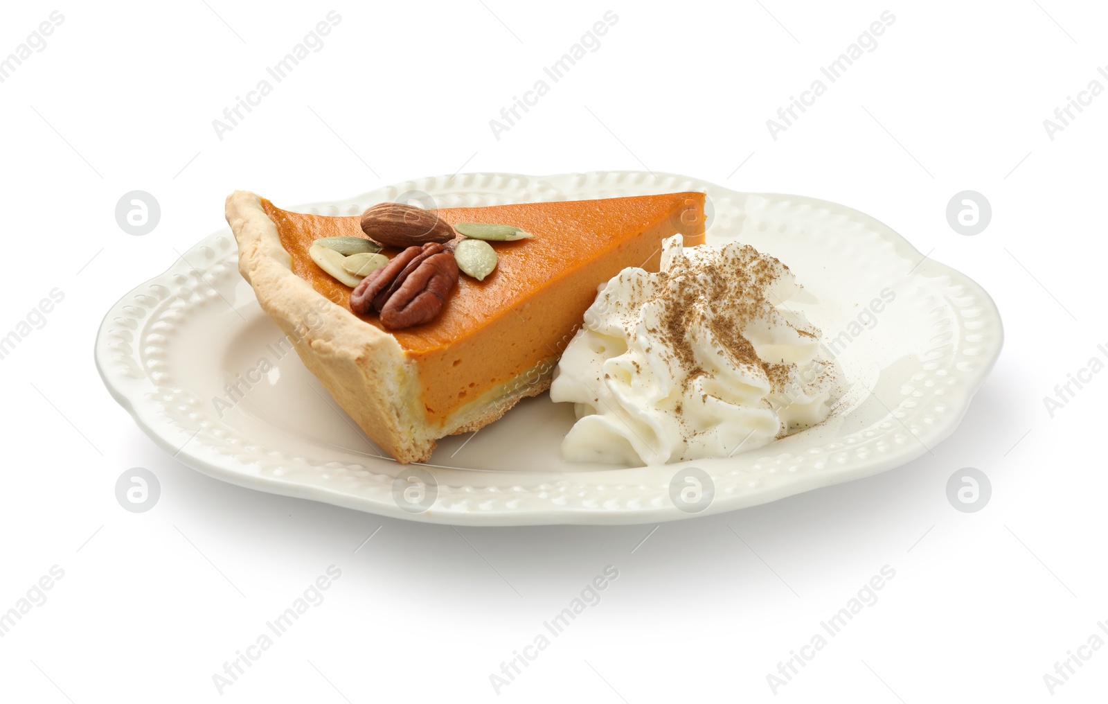 Photo of Piece of tasty homemade pumpkin pie with whipped cream, seeds and nuts isolated on white