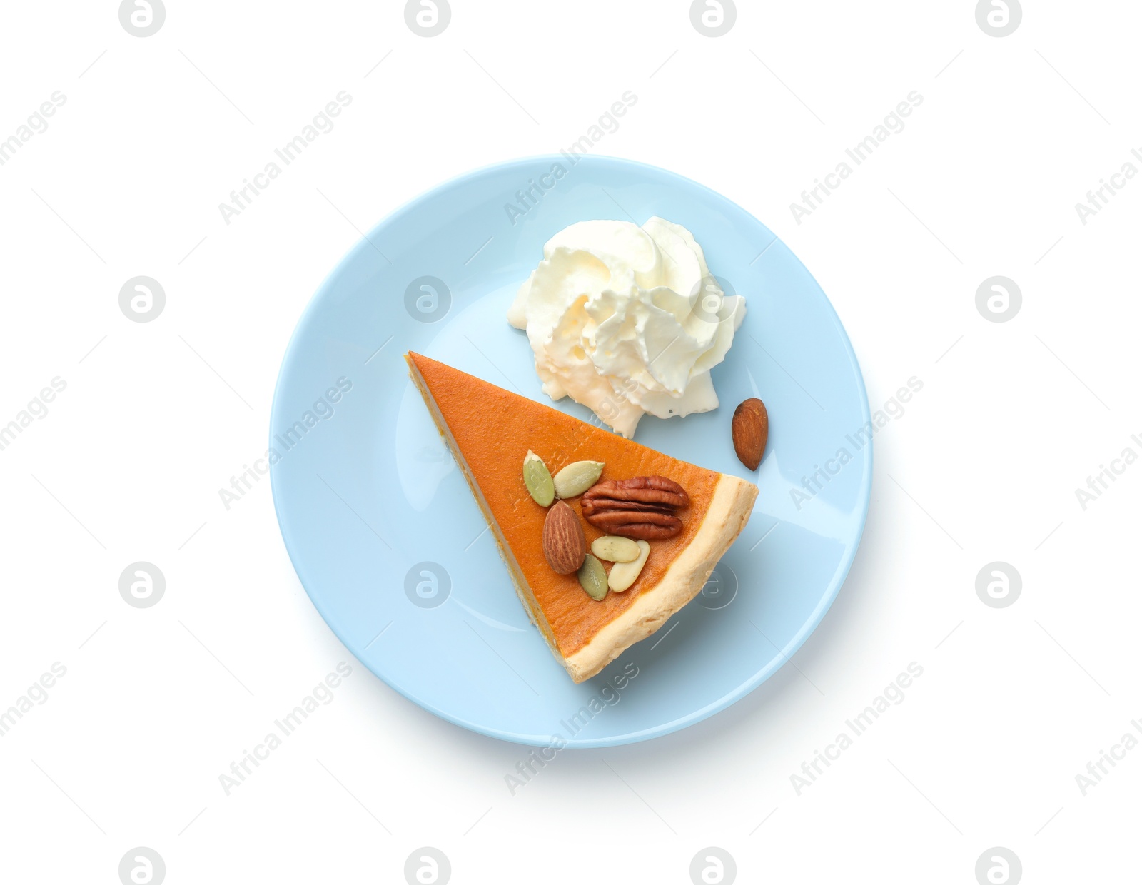 Photo of Piece of tasty homemade pumpkin pie with whipped cream, seeds and nuts isolated on white, top view