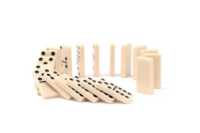 Photo of Domino effect. Tiles falling on white background