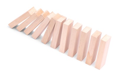 Photo of Domino effect. Wooden blocks falling on white background