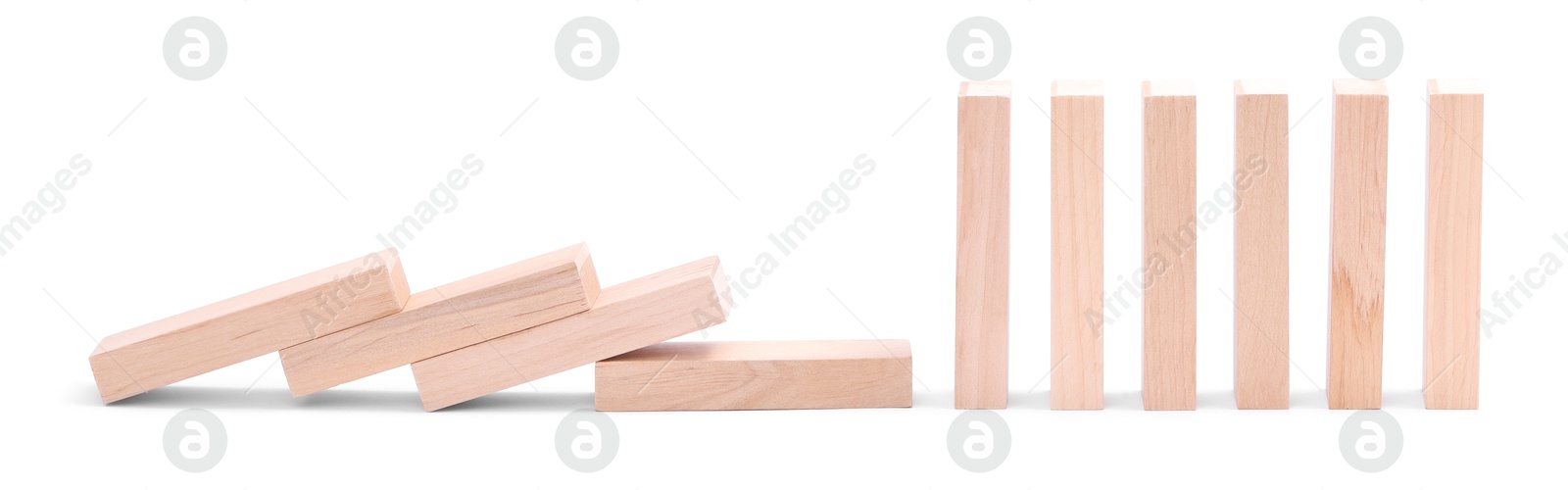 Photo of Domino effect. Wooden blocks falling on white background