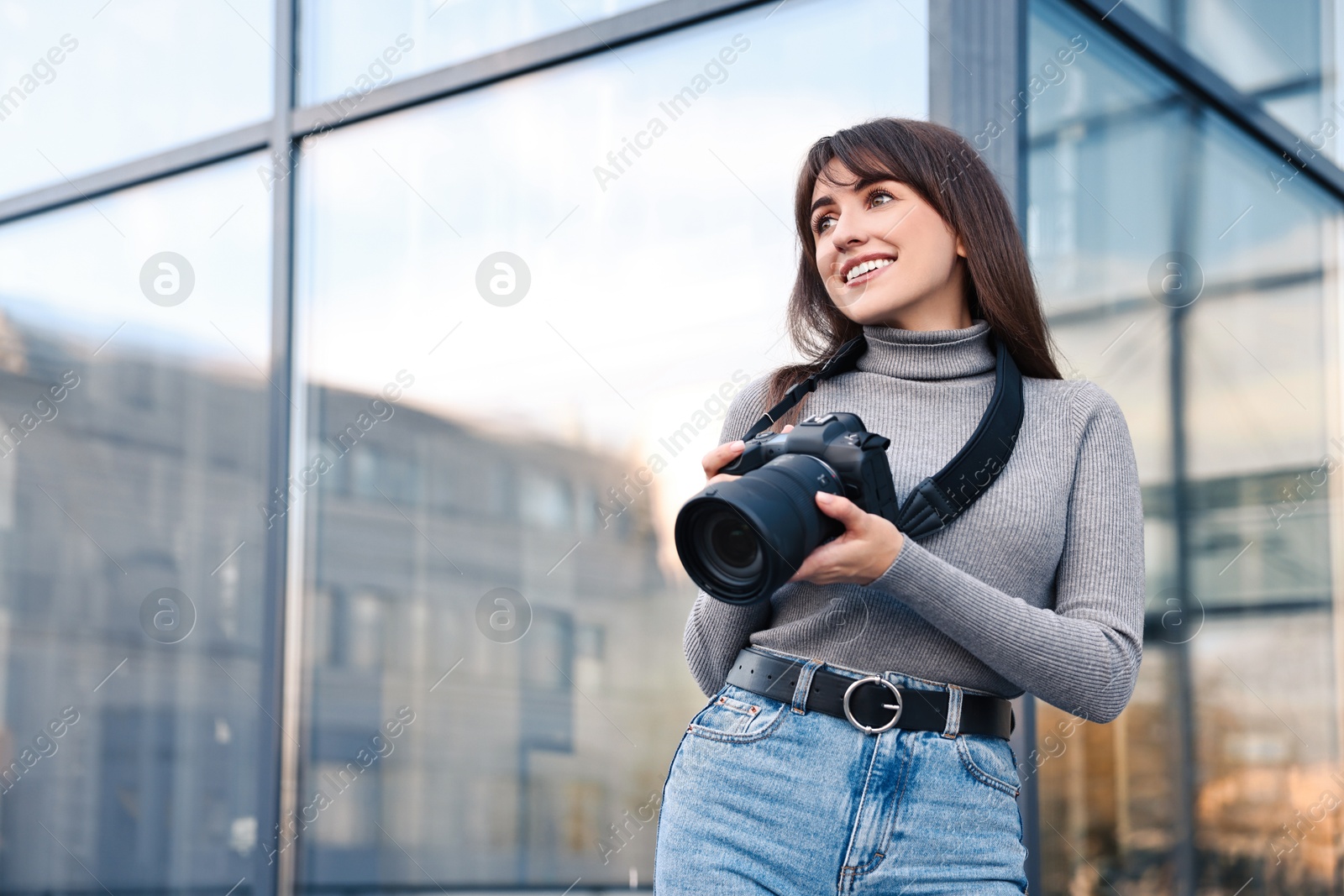 Photo of Professional photographer with digital camera outdoors, low angle view. Space for text