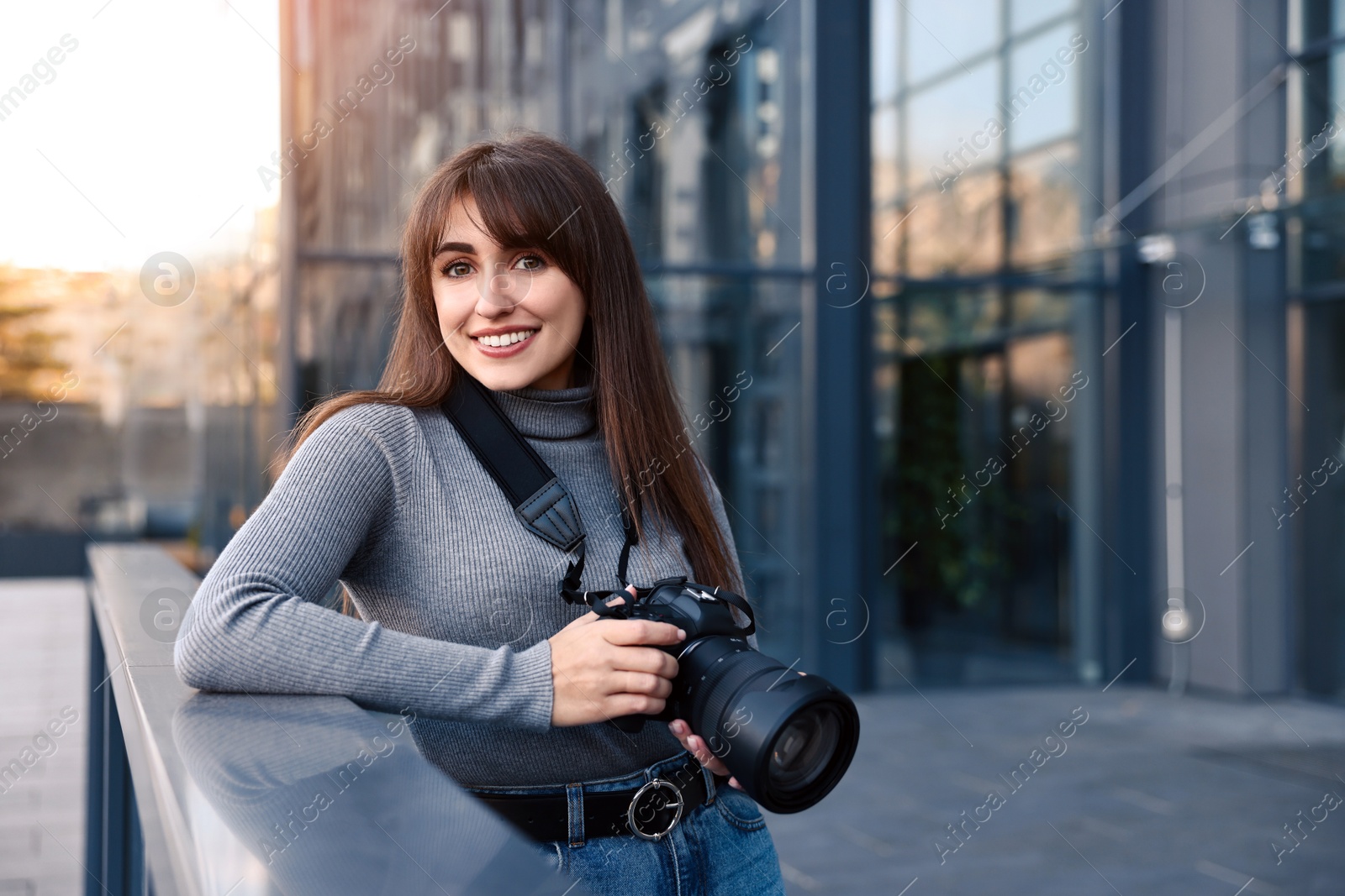 Photo of Professional photographer with digital camera near building outdoors