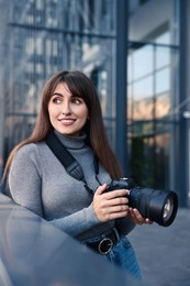 Photo of Professional photographer with digital camera near building outdoors