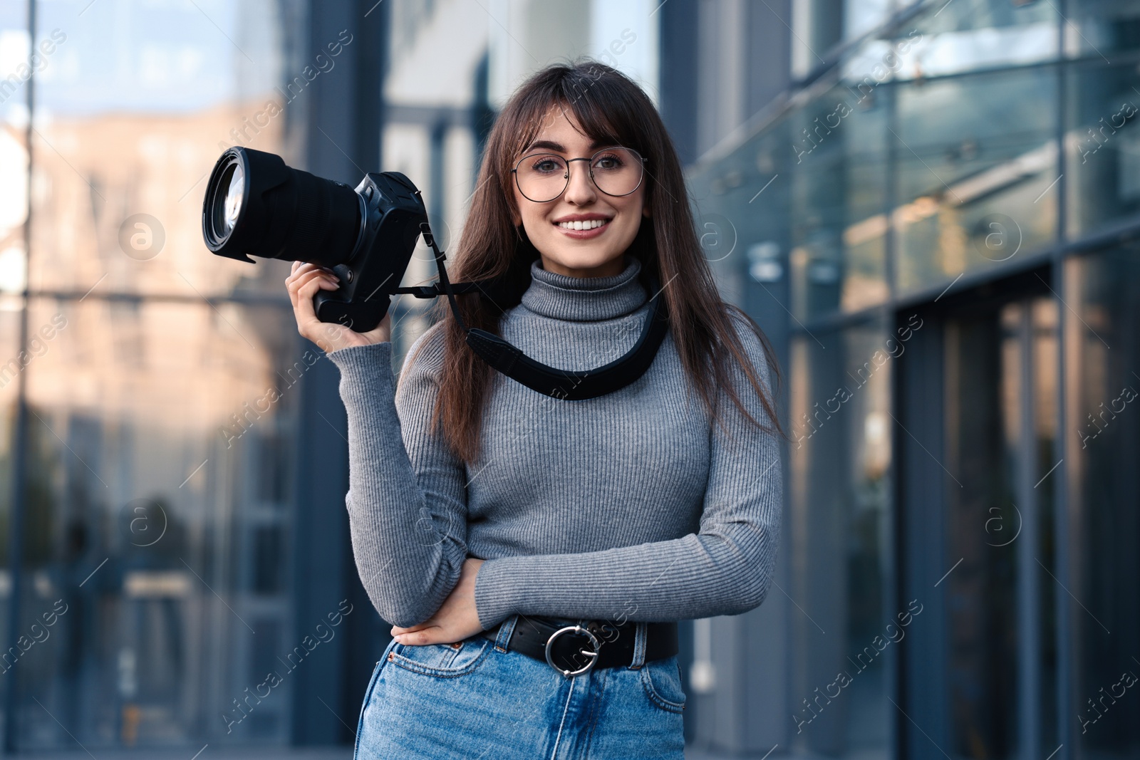 Photo of Professional photographer with digital camera near building outdoors