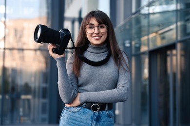 Professional photographer with digital camera near building outdoors