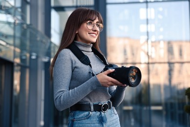 Photo of Professional photographer with digital camera near building outdoors