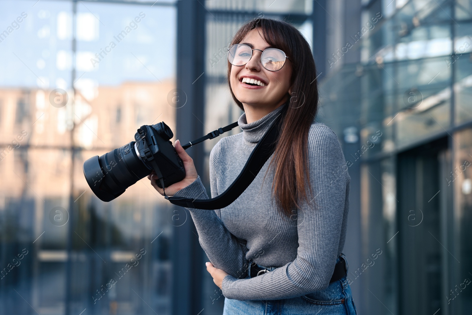 Photo of Professional photographer with digital camera near building outdoors