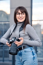 Photo of Professional photographer with digital camera near building outdoors