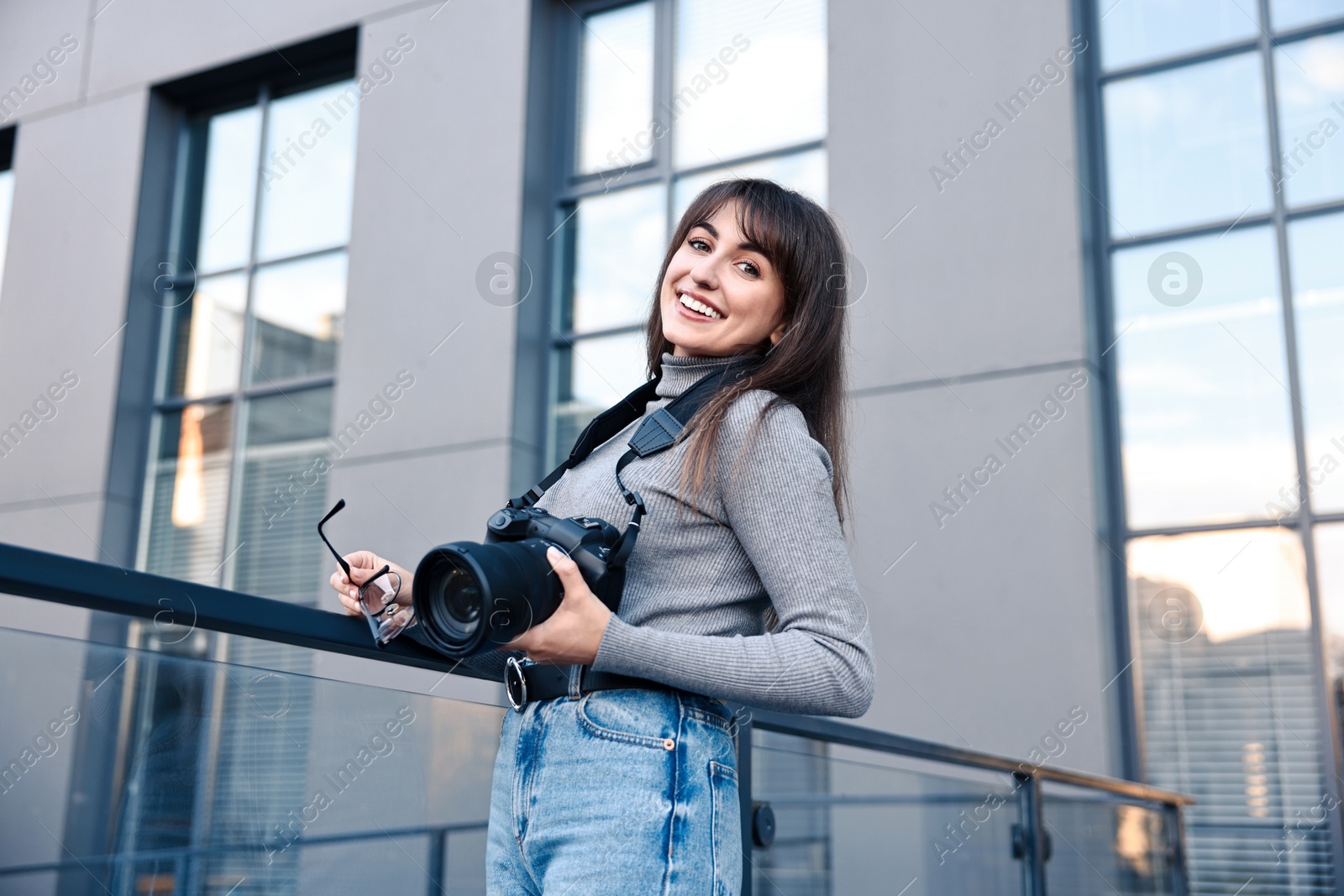 Photo of Professional photographer with digital camera near building outdoors