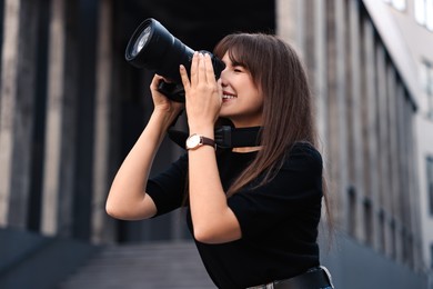 Photo of Professional photographer taking picture with camera outdoors