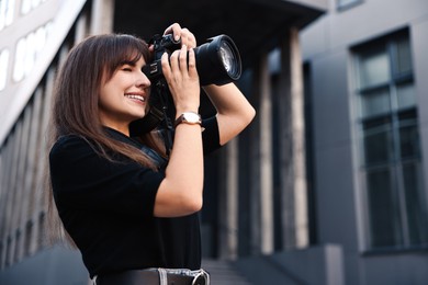 Photo of Professional photographer taking picture with camera outdoors