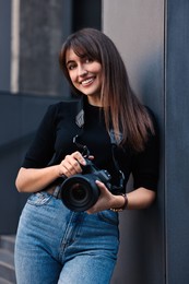 Photo of Professional photographer with digital camera near building outdoors