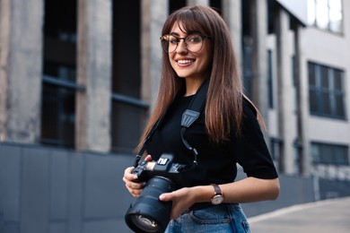 Photo of Professional photographer with digital camera near building outdoors