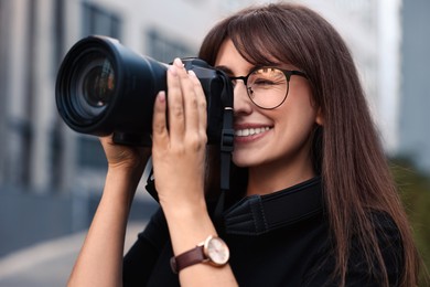 Professional photographer taking picture with camera outdoors