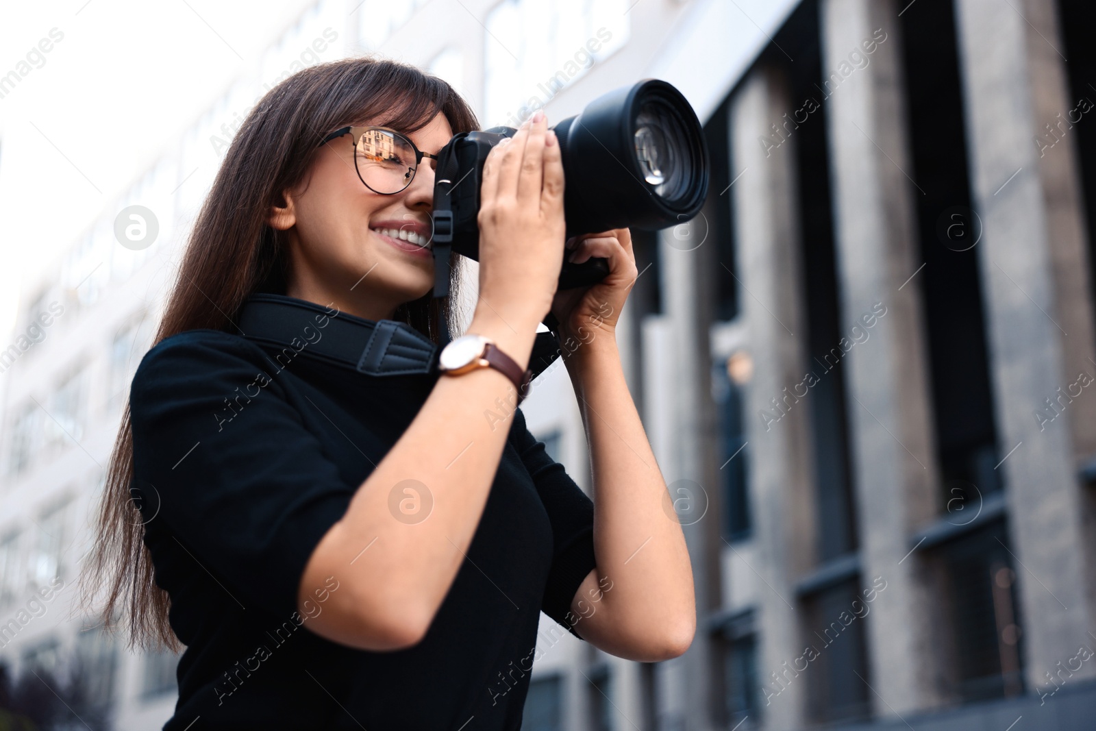 Photo of Professional photographer taking picture with camera outdoors