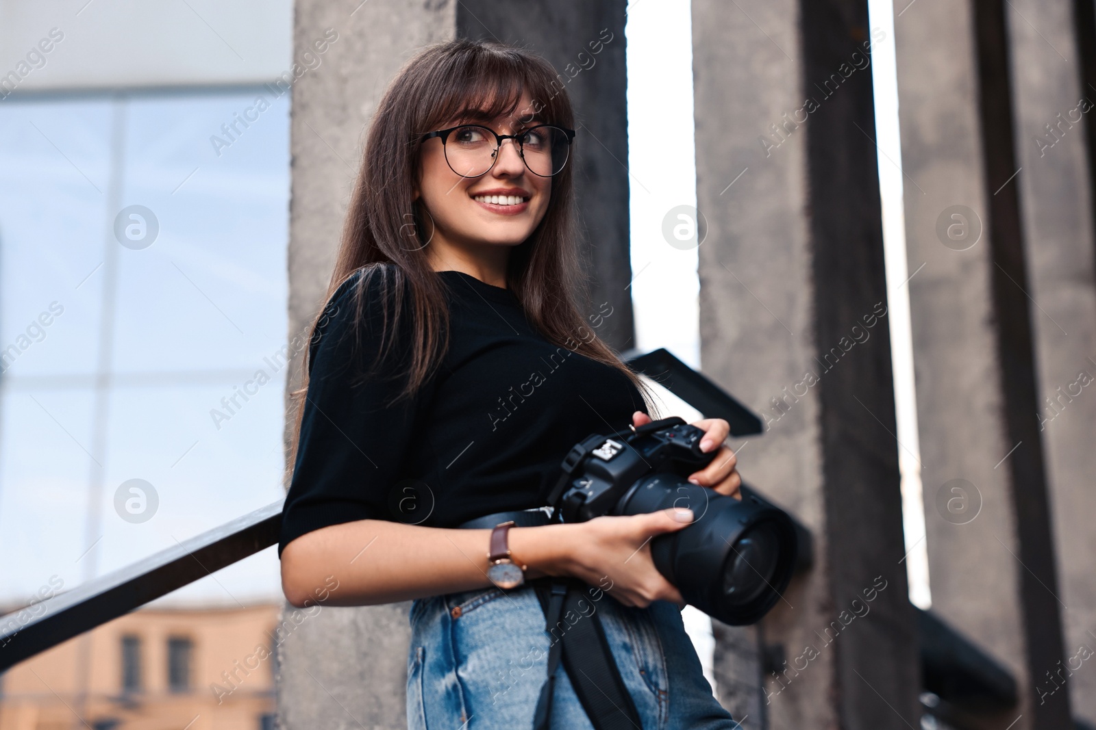 Photo of Professional photographer with digital camera outdoors, low angle view