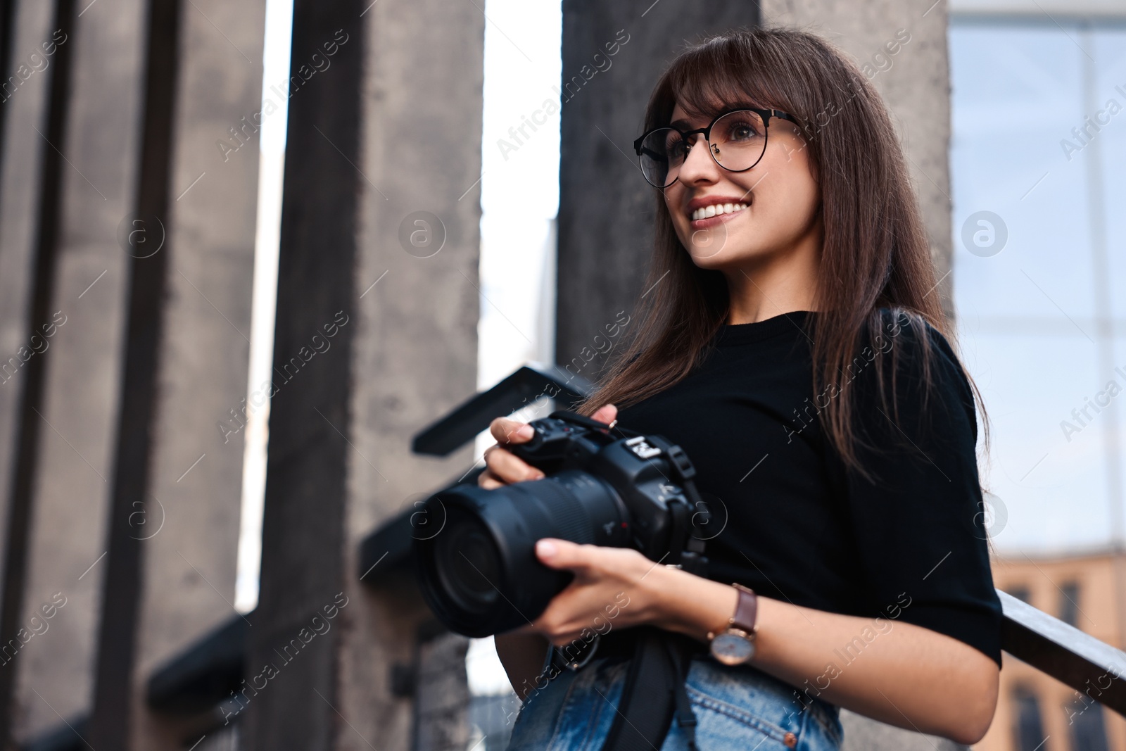 Photo of Professional photographer with digital camera near building outdoors. Space for text