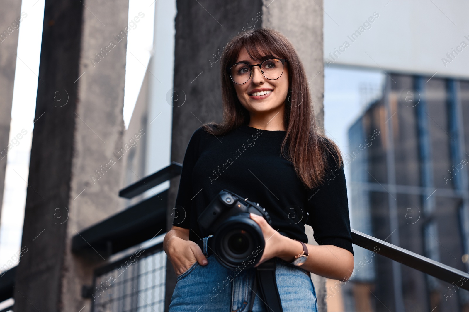 Photo of Professional photographer with digital camera near building outdoors