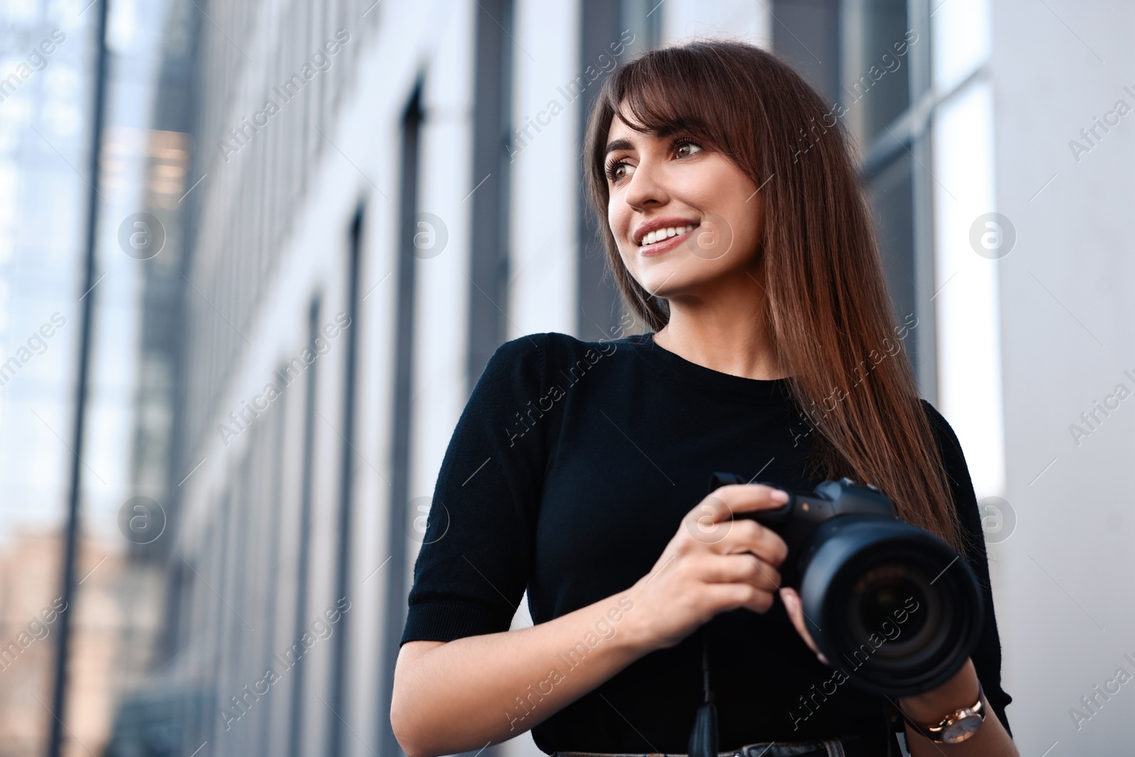 Photo of Professional photographer with digital camera near building outdoors