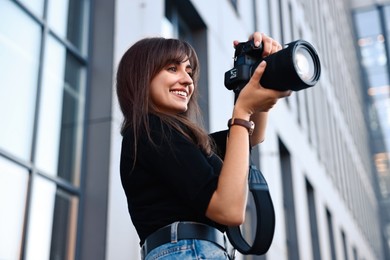 Photo of Professional photographer with digital camera near building outdoors